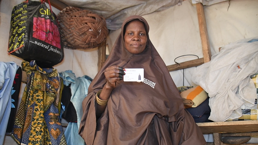 Yafanna Waziri displays her food ticket which doubles as her identity card