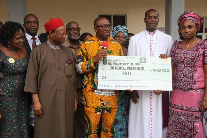 Mr. Obi giving a cheque to a mission hospital while former Commonwealth Secretary General, Emeka Anyaoku,Stella Okunna, and others watching